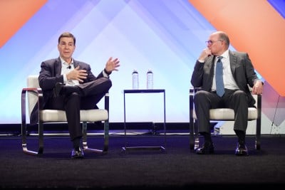 two men talking on stage at ism world conference