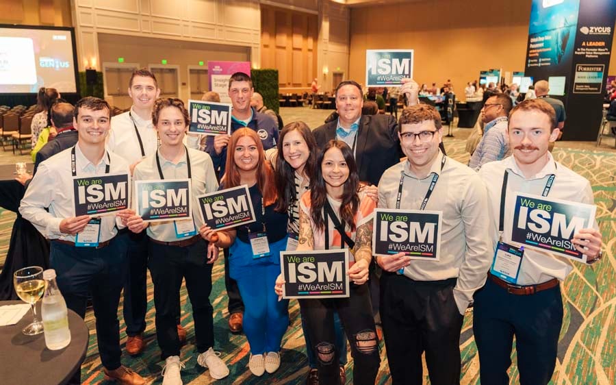 Attendees smiling with sign at ISM World 2025