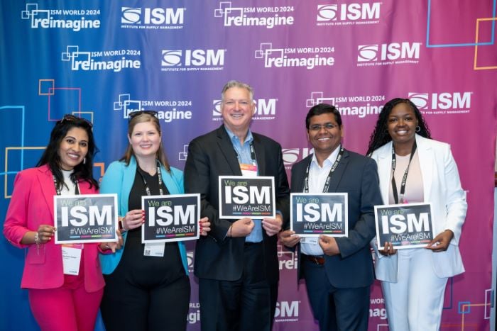 Five people stand in front of an ISM World 2024 backdrop holding ISM signs
