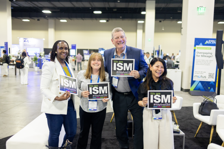 ISM World 2026 Team Experience Photo with 4 people holding ISM signs