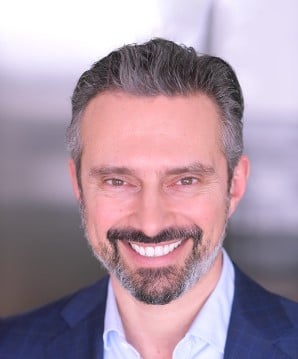 man in blue suite smiling headshot