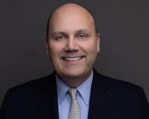 man with blue eyes smiling for headshot photo