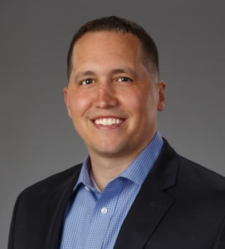 man in black suite smiling