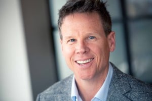 man in grey suite smiling