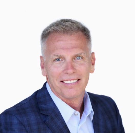 man smiling for headshot photo with suite on blue